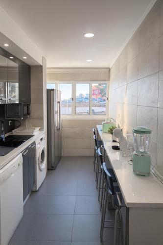 a kitchen with white appliances and a counter with chairs at StaySanto in Loures in Loures
