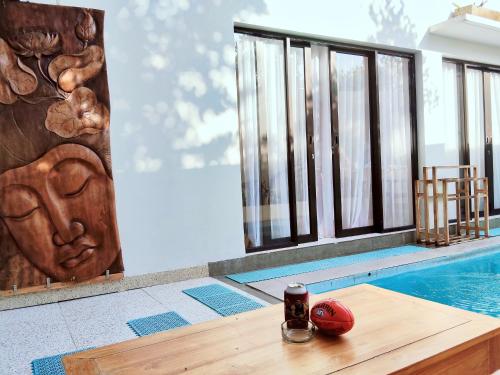 a house with a pool and a table with a drink on it at Peaceful Private 4 BR YY Bali Villa, Jimbaran Nusa Dua, In Central Kuta in Jimbaran
