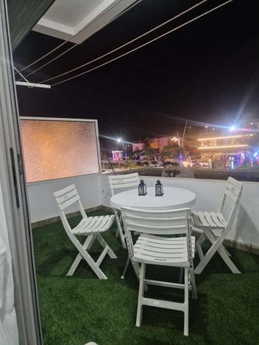 a white table and chairs on a patio at night at Sunny studio with a beautiful terrace in Pont Blondin