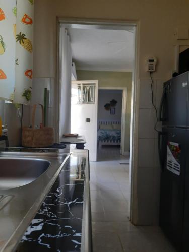 una cocina con fregadero y frigorífico en Reset Home, en Entebbe