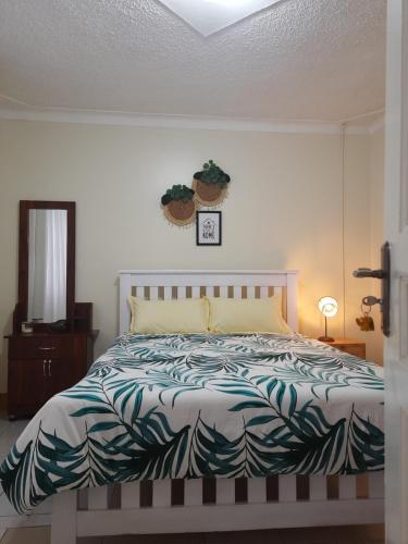1 dormitorio con 1 cama con una planta en la pared en Reset Home, en Entebbe
