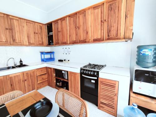 a kitchen with wooden cabinets and a stove top oven at Peaceful Private 4 BR YY Bali Villa, Jimbaran Nusa Dua, In Central Kuta in Jimbaran