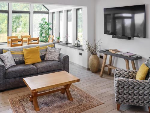 ein Wohnzimmer mit Sofa und Tisch in der Unterkunft Preselli View Cottage - Uk37755 in Ludchurch