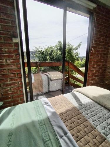 une chambre avec un lit et une grande fenêtre en verre dans l'établissement Vinoteca Vintage, à Piriápolis