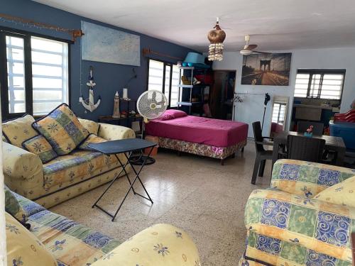 a living room with a couch and a bed at Casita Azul del mar, sencilla con fresca brisa in Chelem