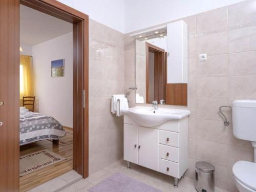 Un baño con lavabo, inodoro y una cama. en One Bedroom Apartment with Balcony and Sea View 2, en Vrboska