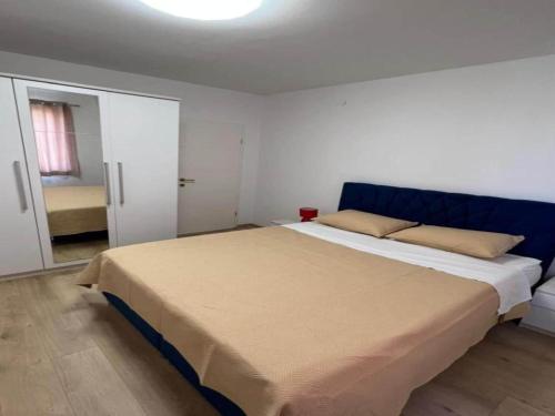 Un dormitorio con una cama grande con cabecero azul. en Four-Bedroom Apartment With Sea View, en Sreser
