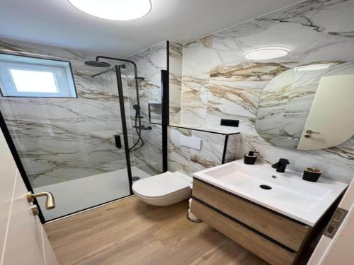 Un baño con ducha, inodoro y lavabo. en Four-Bedroom Apartment With Sea View, en Sreser