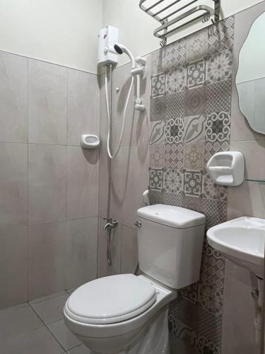 a bathroom with a shower and a toilet and a sink at Filipinas Hostel in Dipolog