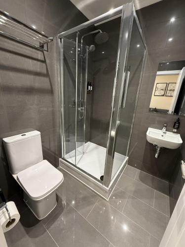 a bathroom with a shower and a toilet and a sink at Apartment 20 @ Excel London in London