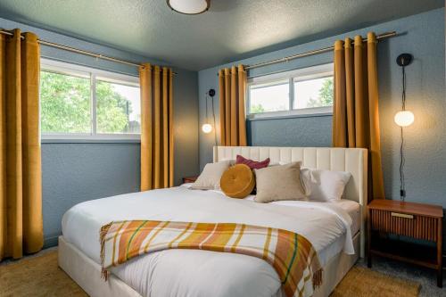 a bedroom with a large white bed with yellow curtains at Sleeps 16 Hot Tub Arcade Movie Theater Pool Table in Westminster