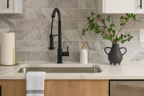 a kitchen sink with a vase and a plant at Sleeps 16 Hot Tub Arcade Movie Theater Pool Table in Westminster