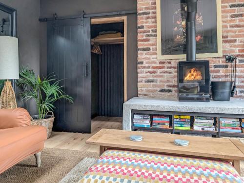 a living room with a fireplace and a couch at Little Barn in Erlestoke