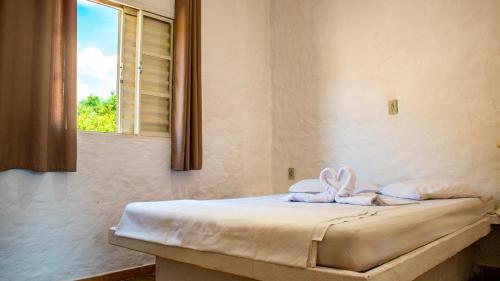 a bed in a room with a window at Parque Pousada Macaquinho Turismo in Serra Negra