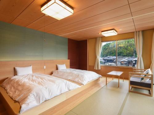 a bedroom with a large bed and a window at 萩八景 雁嶋別荘 in Hagi