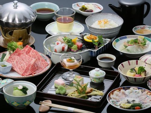 a table topped with bowls and plates of food at 萩八景 雁嶋別荘 in Hagi