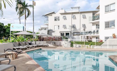 a hotel pool with chairs and a building at Regatta Noosa in Noosaville