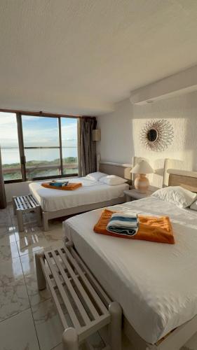 a hotel room with two beds and a window at Solymar Zona Hotelera Cancún in Cancún