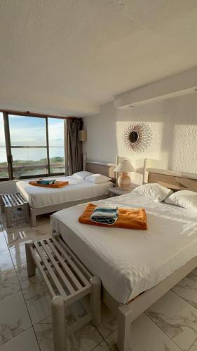 a hotel room with two beds and a window at Solymar Zona Hotelera Cancún in Cancún
