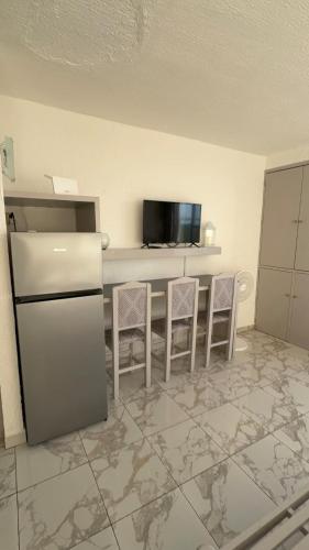 a kitchen with a refrigerator and a counter with stools at Solymar Zona Hotelera Cancún in Cancún