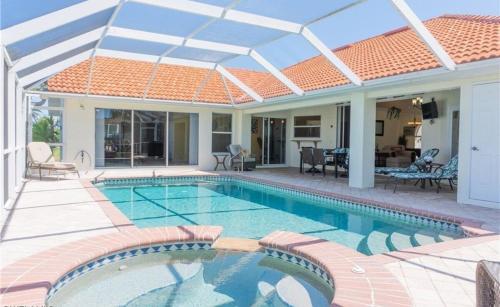 a swimming pool in a house with a roof at Sunshine paradise retreat with heated pool and canal access in Cape Coral