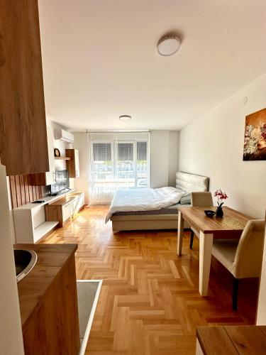 a bedroom with a bed and a table in it at Vidolux Studio - Free Garage and Fast WiFi in Niš