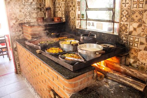 a kitchen with pots and pans of food on a stove at Parque Pousada Macaquinho Turismo in Serra Negra