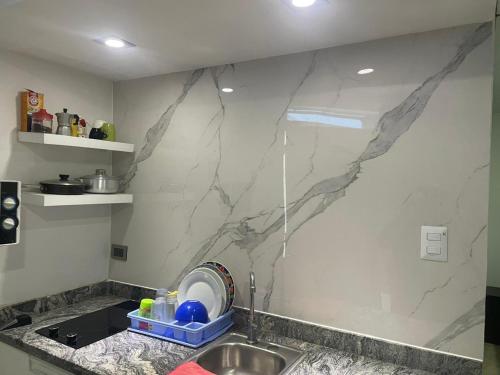 una cucina con un lavandino e una parete di marmo di Mar azul puerto plata a San Felipe de Puerto Plata