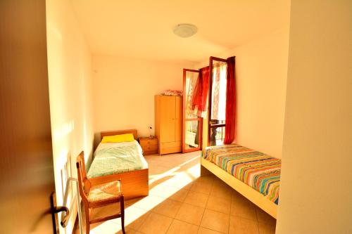 シルミオーネにあるSarno Apartments Via Tintorettoのベッドルーム1室(ベッド1台、椅子、窓付)