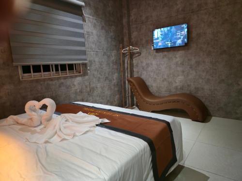 a bedroom with two swans on a bed with a tv at NP Luxury Motel in Ấp Hưng Lộc