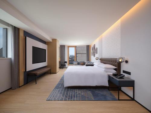 a hotel room with a bed and a flat screen tv at Four Points by Sheraton Xi'an Dayan Pagoda in Xi'an