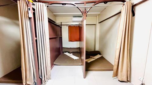 a walk in shower in a room with curtains at Golden 8 Airport Hostel - Mactan Cebu in Pusok