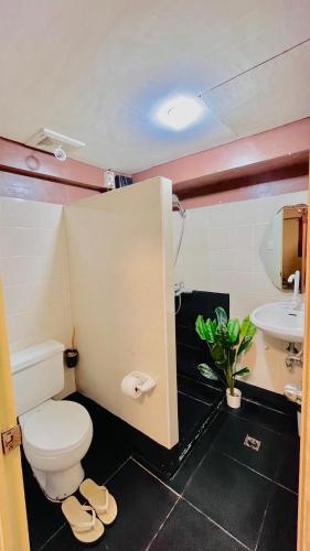 a bathroom with a toilet and a sink at Golden 8 Airport Hostel - Mactan Cebu in Pusok