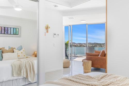 a bedroom with a bed and a view of the ocean at Luxe at Oshen Yeppoon in Yeppoon