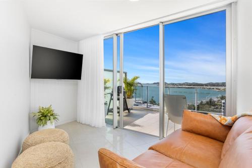 a living room with a couch and a view of the ocean at Luxe at Oshen Yeppoon in Yeppoon
