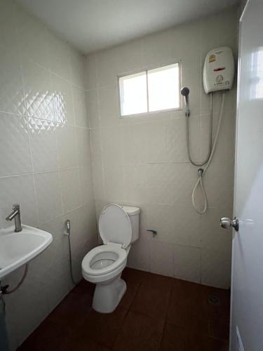a bathroom with a toilet and a sink and a shower at กรีนเกสท์เฮ้าส์ พนัสนิคม in Phanat Nikhom