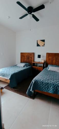 a bedroom with two beds and a ceiling fan at El paraíso del descanso in El Jobo