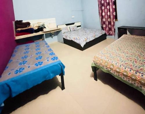 een kamer met 2 bedden en een bureau. bij Preet Guest House in Kedārnāth