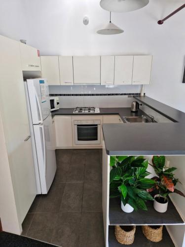 a small kitchen with white cabinets and a sink at Villa Cooloola Calm - C709, Kingfisher Bay Resort in Kingfisher Bay