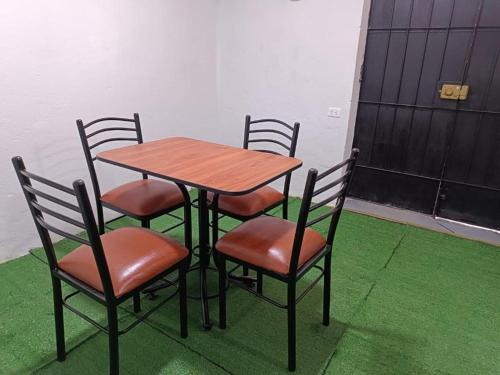 a wooden table and four chairs and a table and chairs at Hospedaje - A y C Taxi- Airport - Accommodation in Lima
