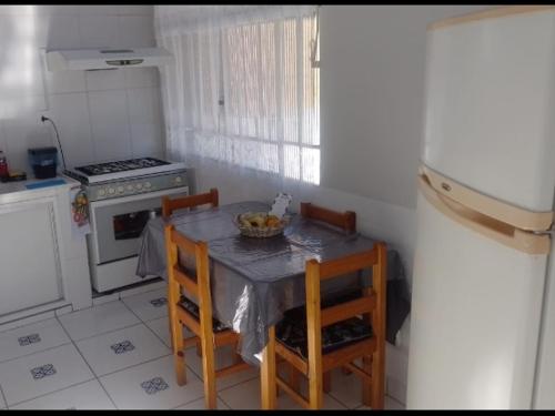 a kitchen with a table and chairs with a bowl of fruit on it at Casa da Lu in Aparecida
