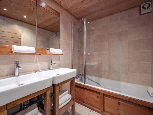 a bathroom with two sinks and a shower and a tub at Chalet à Méribel avec service de conciergerie et animaux admis - FR-1-613-143 in Méribel