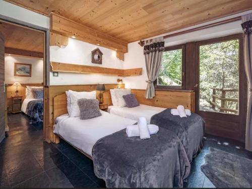 two beds in a room with wooden walls at Chalet à Méribel avec service de conciergerie et animaux admis - FR-1-613-143 in Méribel