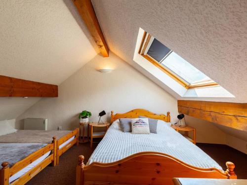 ein Schlafzimmer mit einem Holzbett und einem Dachfenster in der Unterkunft T3 lumineux pour 6 personnes au cœur de Saint-Lary - FR-1-296-526 in Saint-Lary-Soulan