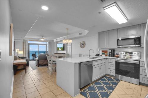 a kitchen with white cabinets and a living room at Anderson Ocean Club #1611 in Myrtle Beach