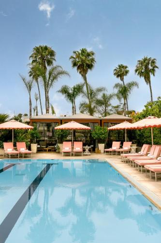 a swimming pool with chairs and umbrellas at Four Seasons Hotel Los Angeles at Beverly Hills in Los Angeles