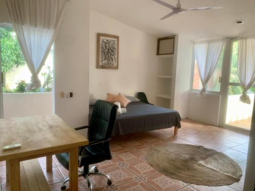 une chambre avec un lit, un bureau et des fenêtres dans l'établissement Casa del Alma, à Puerto Escondido