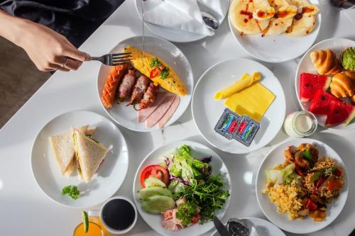 Una mesa blanca con platos de comida encima. en Richico Apartments And Hotel, en Da Nang