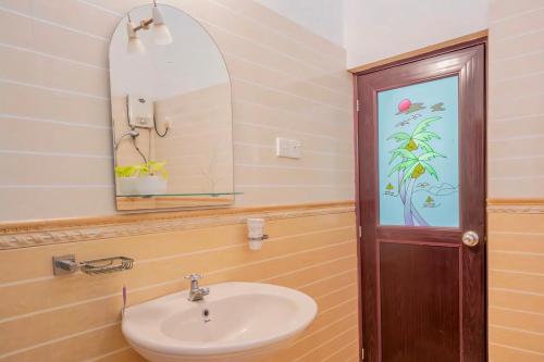 a bathroom with a sink and a mirror at Roamers Ark Galle in Galle