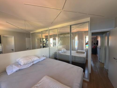 Un dormitorio con dos camas y un gran espejo. en Casa de condominio mobiliada Prox. MOTOGP, en Goiânia